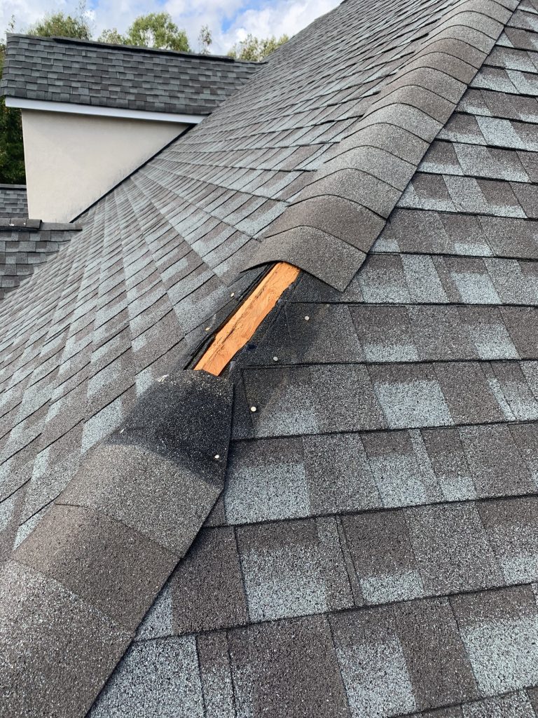Example of missing roof shingles blown off by high winds. 