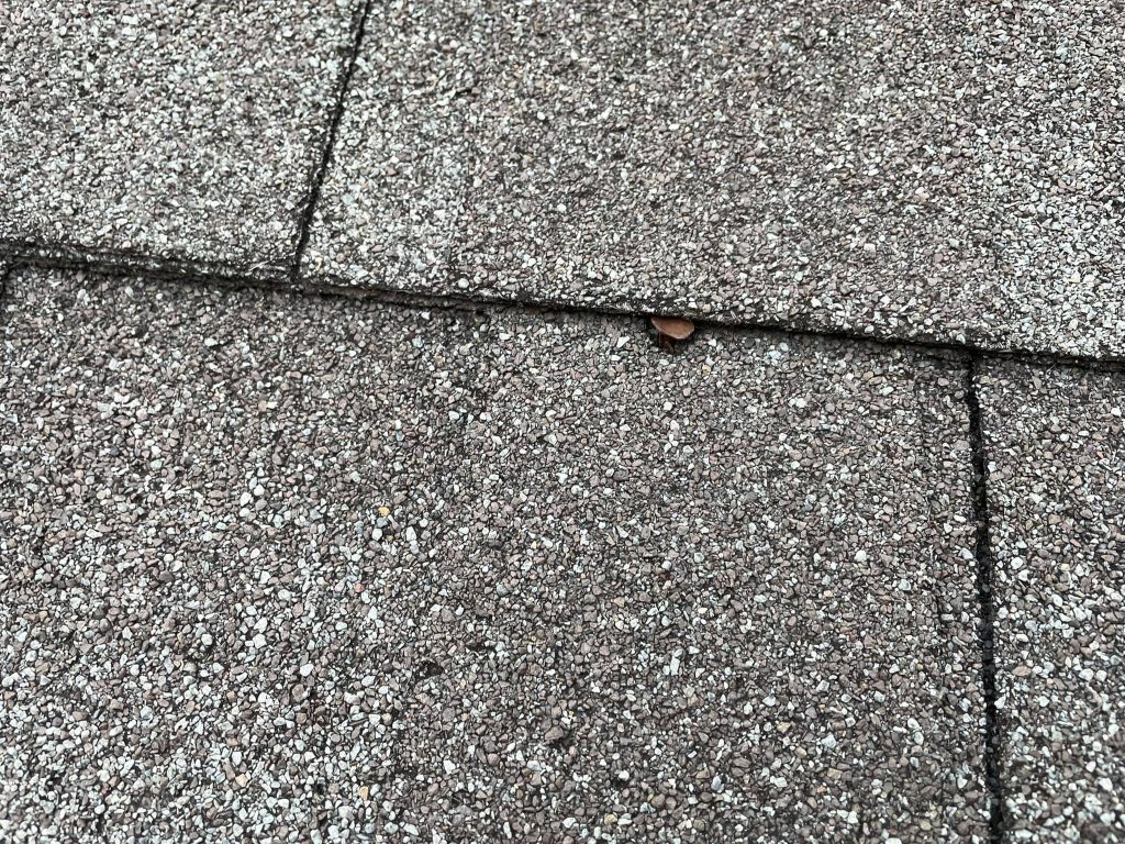 Example of a low nail on a shingle roof.
